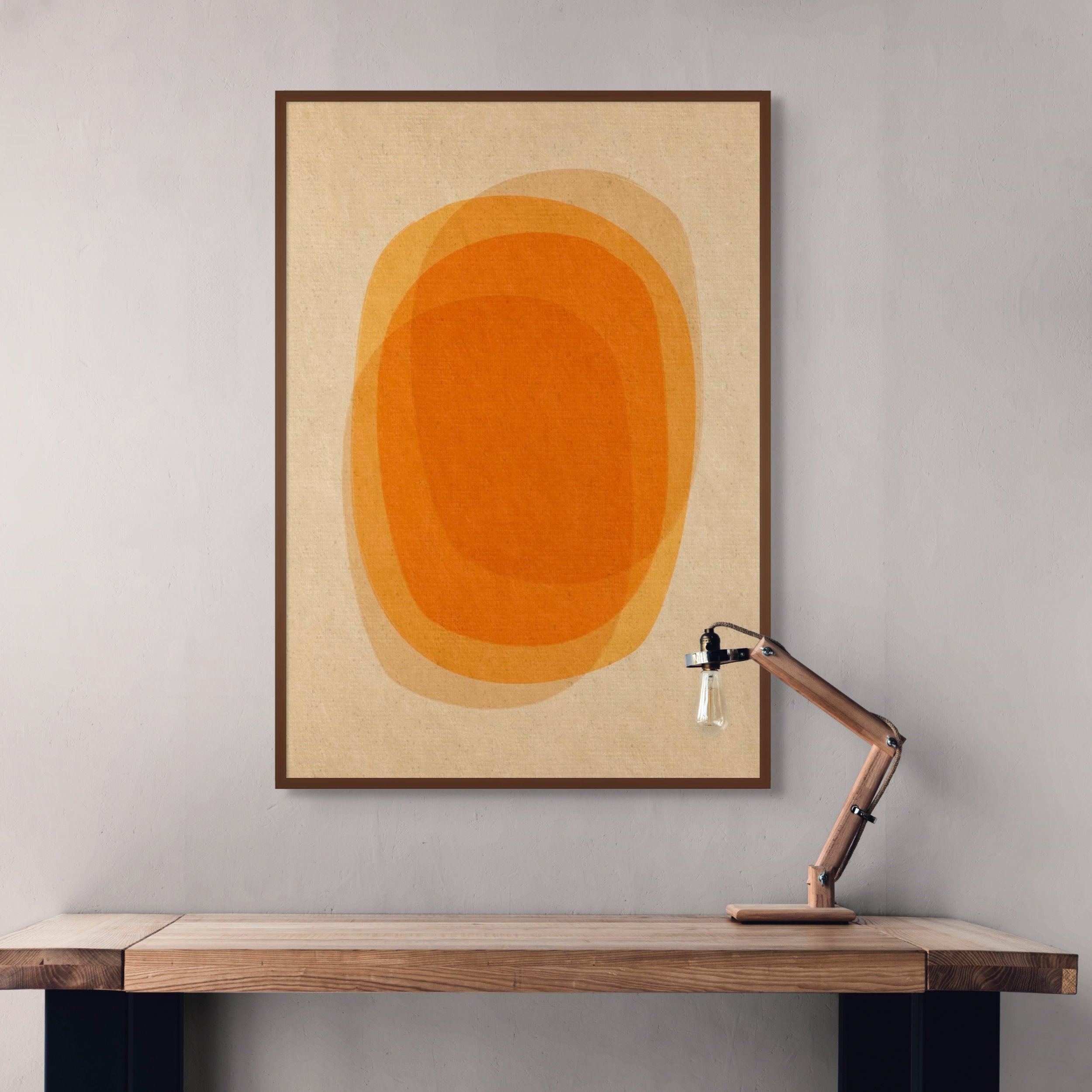 Abstract orange geometric print in a wooden frame displayed above a desk, representing the Standalone Prints collection