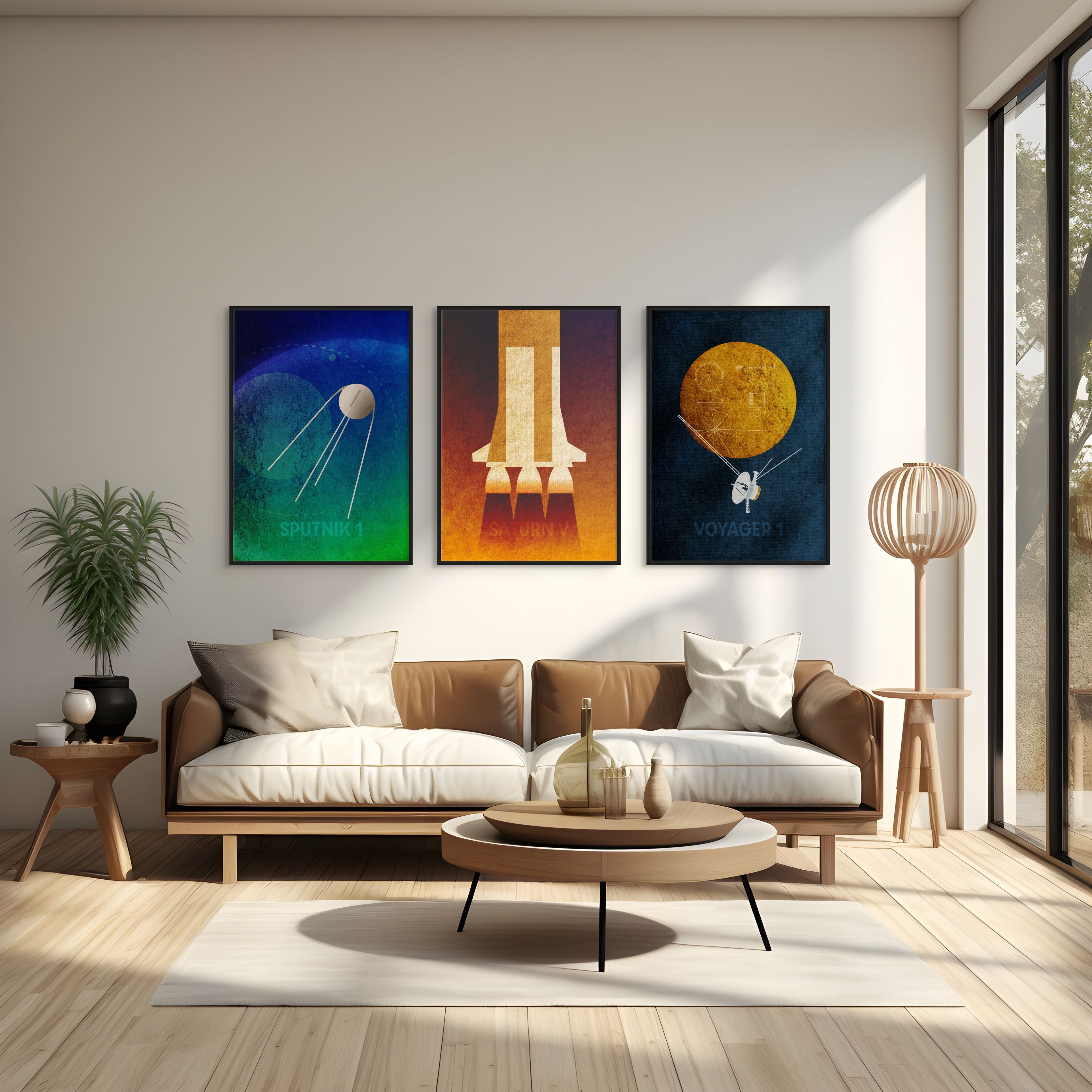 Set of three minimalist space art prints featuring Sputnik 1, Saturn V, and Voyager 1 displayed above a sofa in a modern living room.