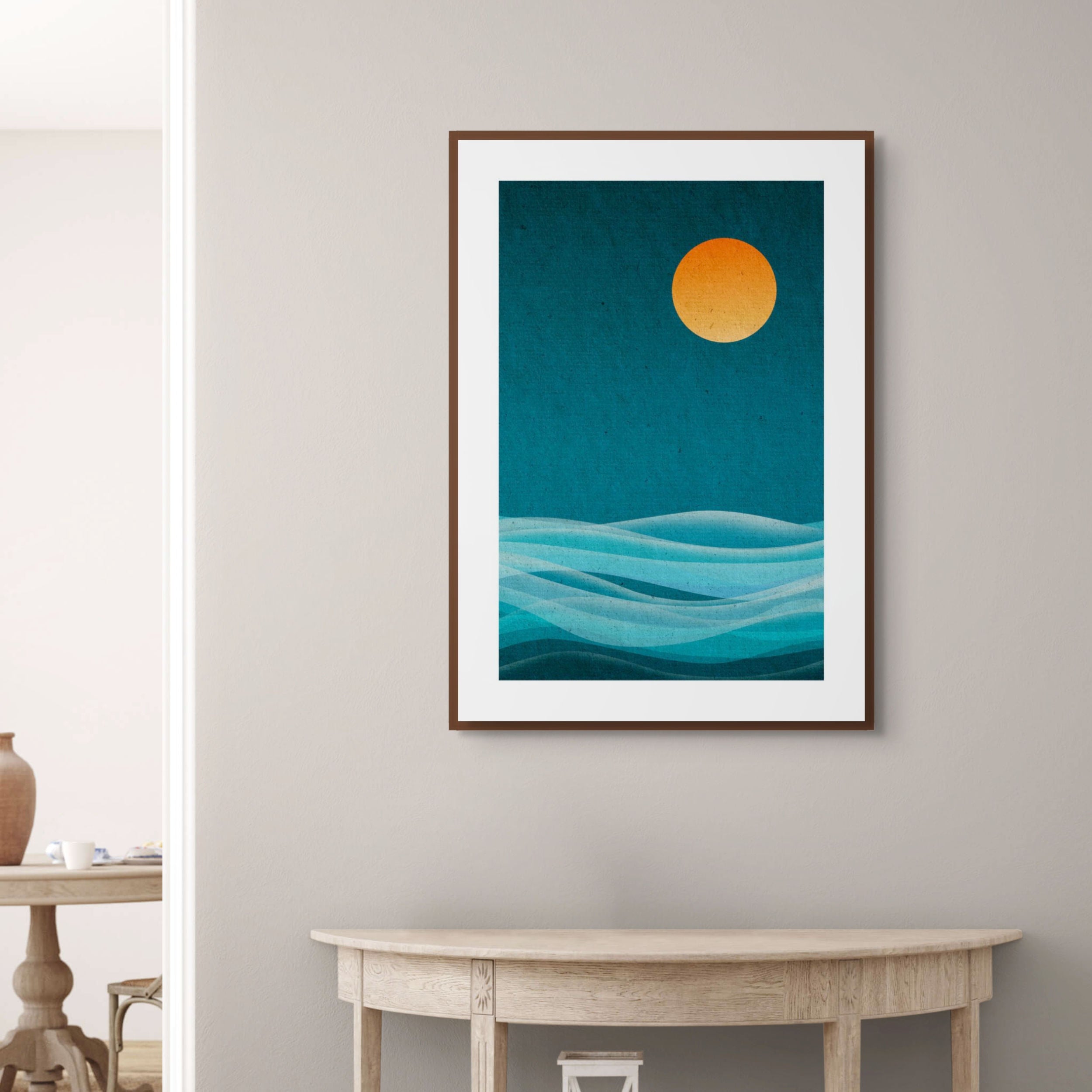 Cool Drift geometric abstract print displayed in a calm modern interior, framed artwork with layered blue wave forms above a wooden console table.