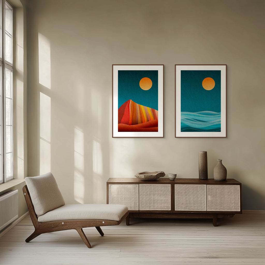 Two framed abstract prints from the Quiet Forms collection, featuring bold landscape-inspired shapes in warm orange and cool blue tones, styled above a wooden sideboard in a minimalist interior.