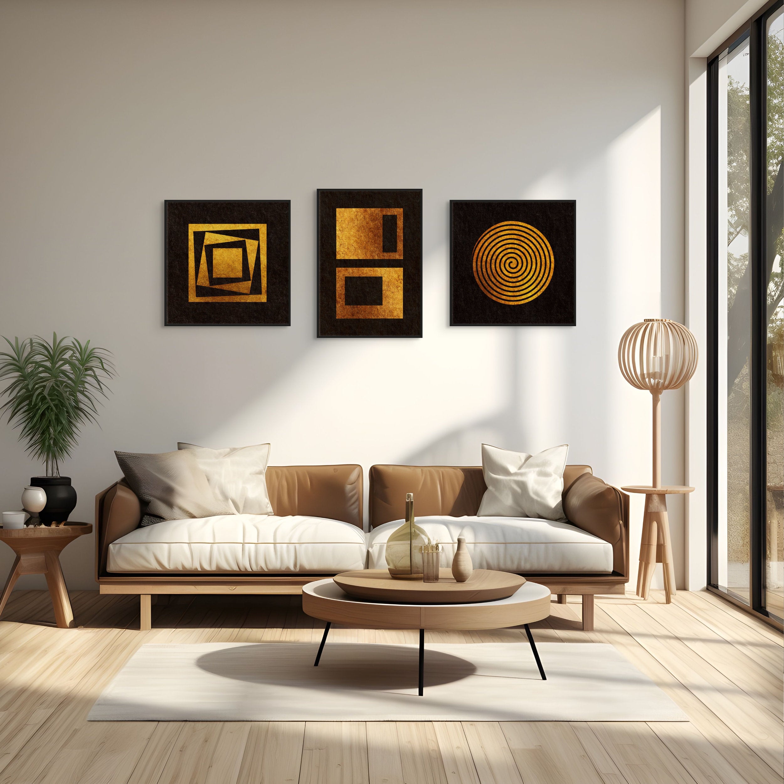 Quiet Geometry collection mockup featuring three black and gold abstract geometric prints displayed above a tan leather sofa in a modern minimalist interior.